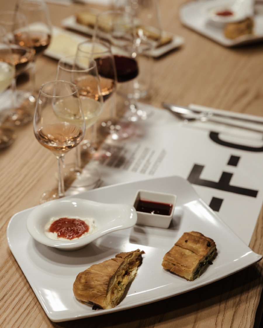 Glasses of rosé and red beside a plate of cheese pies at a PFC tasting