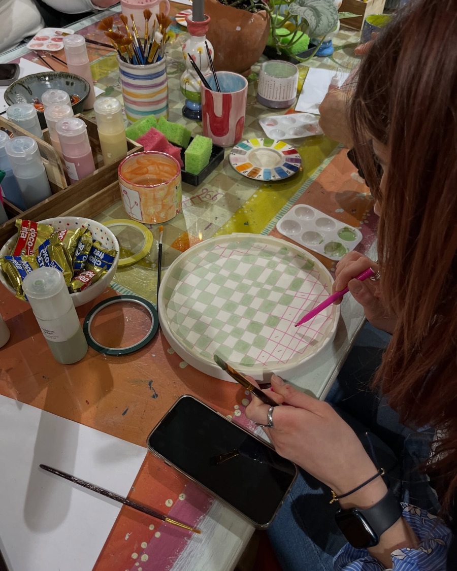 A checked pattern being painted onto a ceramic plate at Yiart