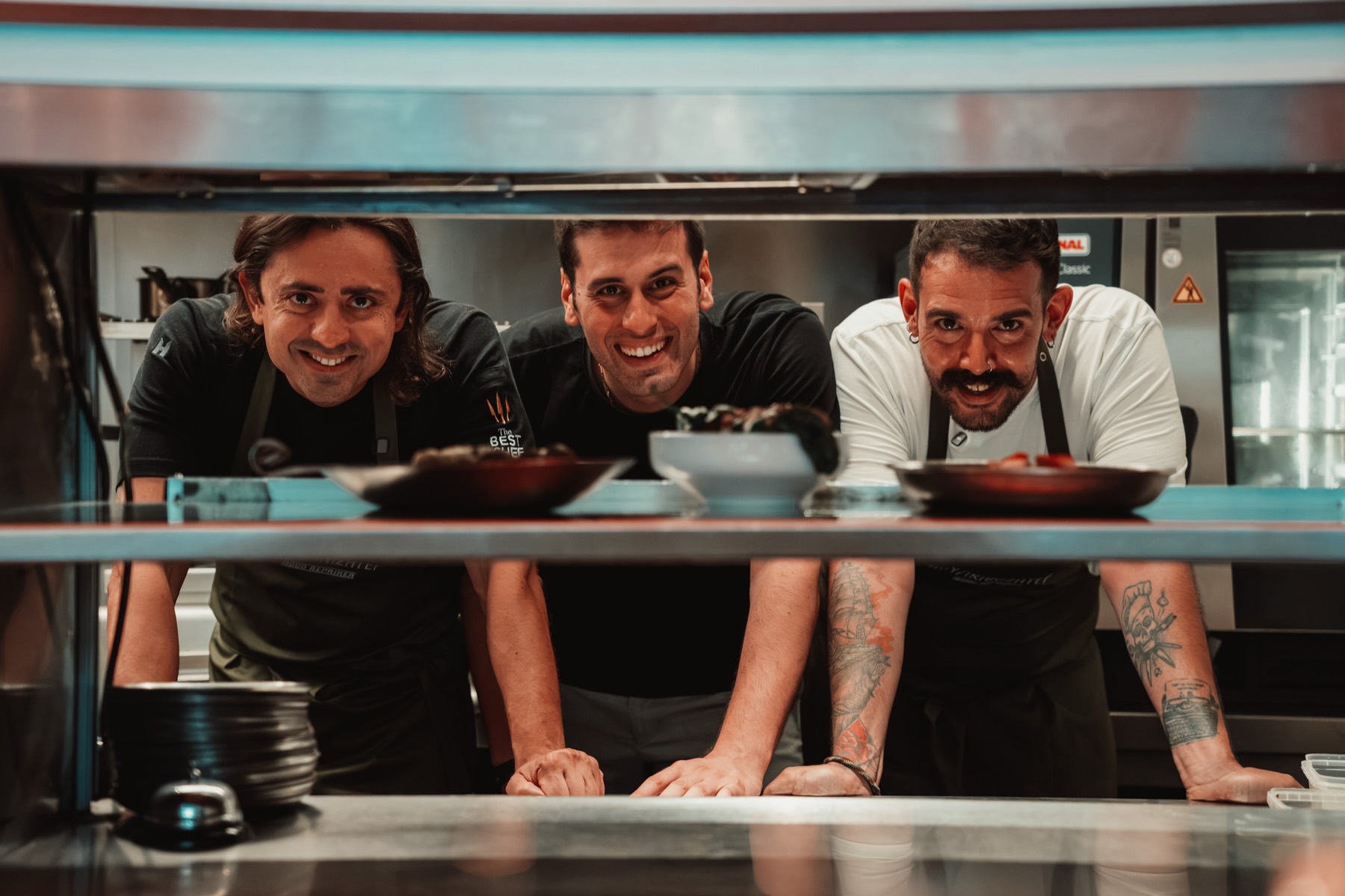 Pavlos Mavridis with Pavlos Kyriakis and the Voulkanizater chef, leaning over the pass